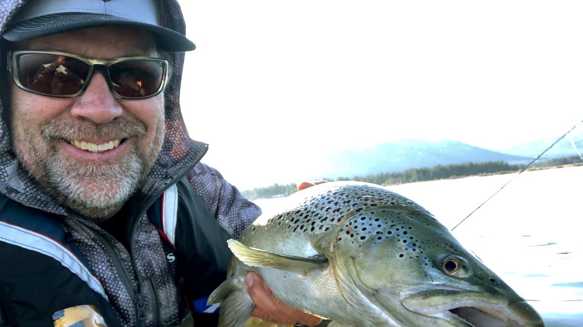 JD Richey, a South Lake Tahoe fishing guide, holds a brown trout he caught on a recent morning on a solo fishing trip on the lake. Richey says his daily fishing trips are what’s keeping him from being crushed with worry as the COVID-19 crisis has forced him to shut his business down, cutting off his sole source of income.