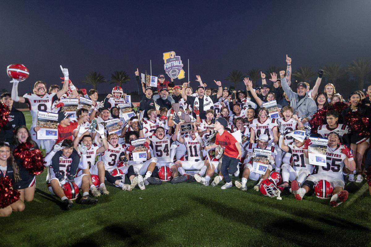 The Winters Warriors celebrate after the 28-7 victory over the Morse Tigers in the CIF Division 6-A State Championship football game at Buena Park High School in Buena Park on Saturday.