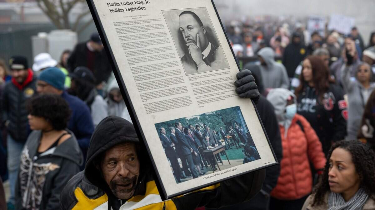 A marcher carries a portrait of the Rev. Martin Luther King Jr. during the Martin Luther King Jr. “Walk With Me” event at Sacramento City College on Monday, Jan. 19, 2026. Liberty endures through imagination and hopeful resistance, from the Declaration of Independence to modern movements for justice and freedom.