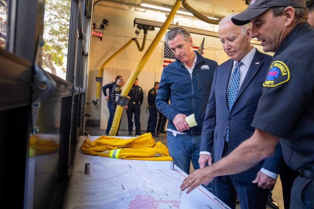 Gov. Gavin Newsom and President Joe Biden are briefed on the Palisades Fire and other blazes in the Los Angeles area at Santa Monica Fire Station No. 5 on Wednesday. Biden has quickly approved California’s request for federal assistance as the blazes destroyed more than 1,000 homes and killed two people.