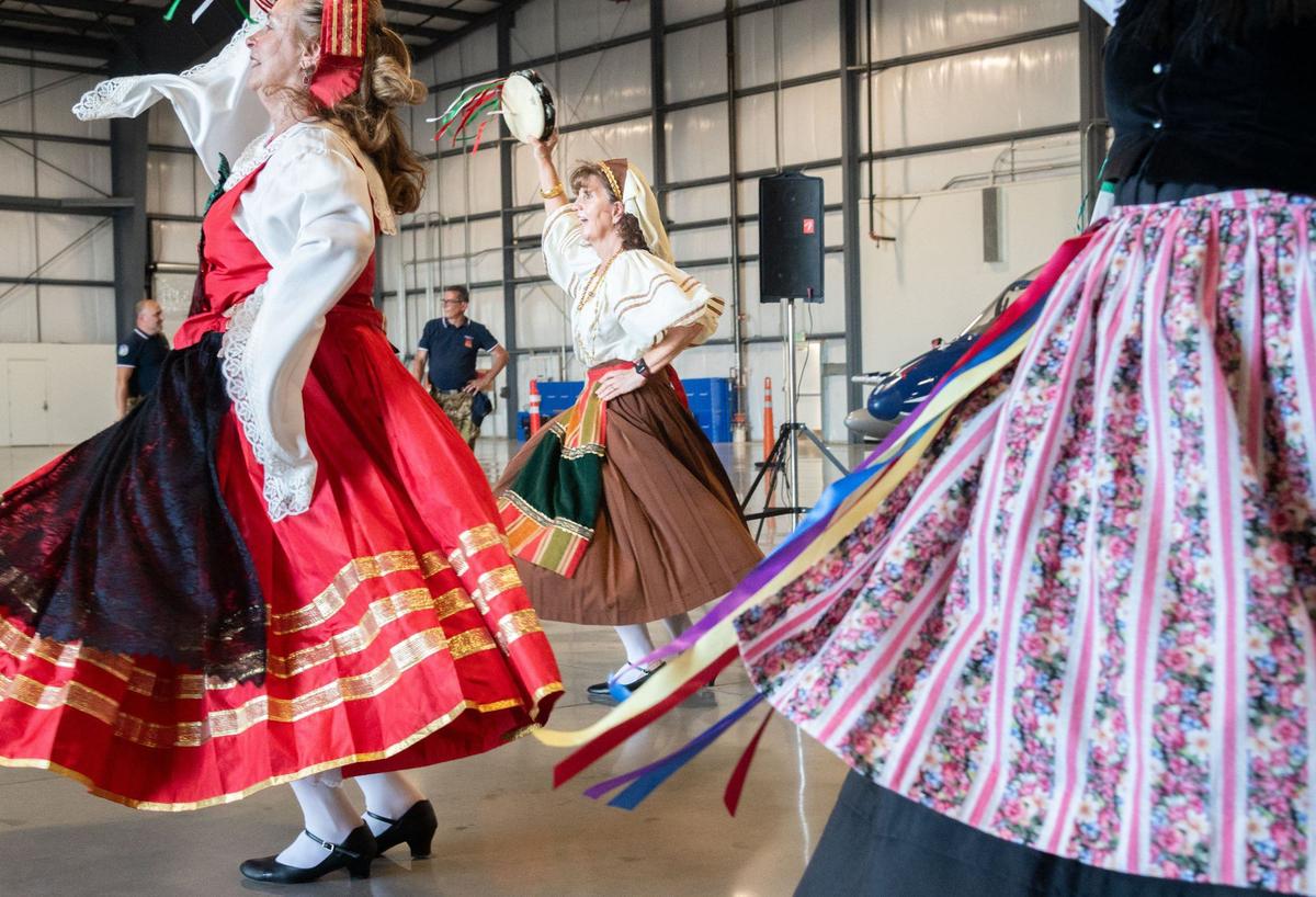 Sue Bonnici-Coleman, center, spins along with other members of the Balliamo Italian dance troupe as part of a greeting for the Frecce Tricolori jet team at Mather Airport near Rancho Cordova on Tuesday, July 9, 2024. The Italian air force team is slated to perform in this weekend’s California Capital Airshow. “What a thrill to see the pilots,” she said.