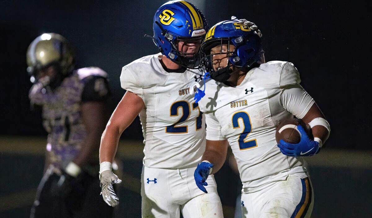 The Sutter Huskies' Losi Asiata (2) is congratulated by fellow running back Gary Bicknell (21) after a fourth quarter touchdown against the Bradshaw Christian Pride in Vineyard on Friday.