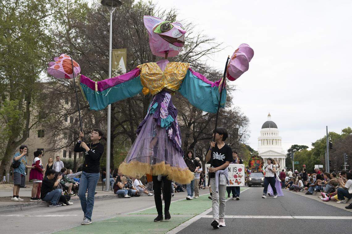 A giant cat puppet parades down Capitol Mall during the City of Trees Parade in Sacramento on Saturday, Feb. 28, 2026.