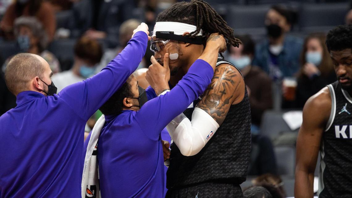 Sacramento Kings center Richaun Holmes (22) gets help with his headgear during a timeout as they play the LA Clippers in the first half of the NBA basketball game Wednesday, Dec. 22, 2021, at Golden 1 Center in Sacramento.