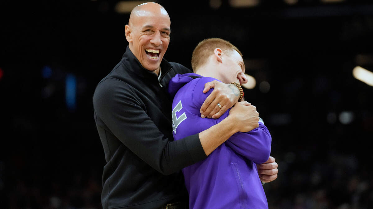 Sacramento Kings assistant coach Doug Christie and guard Donte DiVincenzo (0) joke around during the first half of an NBA basketball game against the Phoenix Suns, Sunday, April 10, 2022, in Phoenix. (AP Photo/Rick Scuteri)