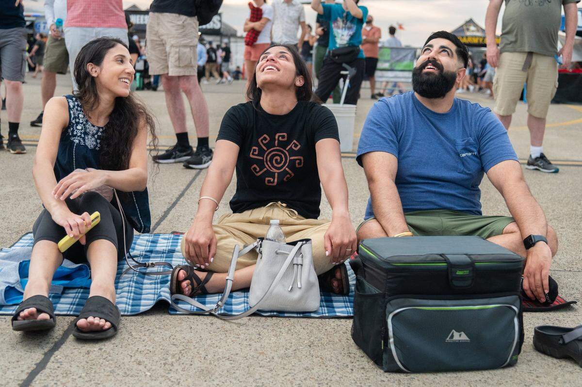 Anmol Dhillon, left, Kira Dhillon, center, and Sanjay Kajla watch an aerial performance during the California Capital Airshow at Mather Airport near Rancho Cordova on Saturday, July 13, 2024. “I used to be in the Air Force National Guard, so I wanted to see the jets,” Anmol Dhillon said.
