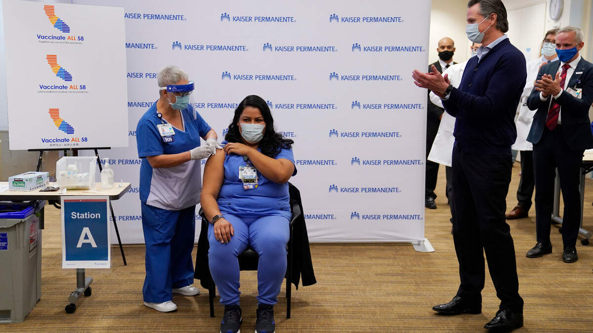 California Gov. Gavin Newsom looks on, far right, as ICU nurse Helen Cordova receives the Pfizer-BioNTech COVID-19 vaccine at Kaiser Permanente Los Angeles Medical Center in Los Angeles on Monday, Dec. 14, 2020.