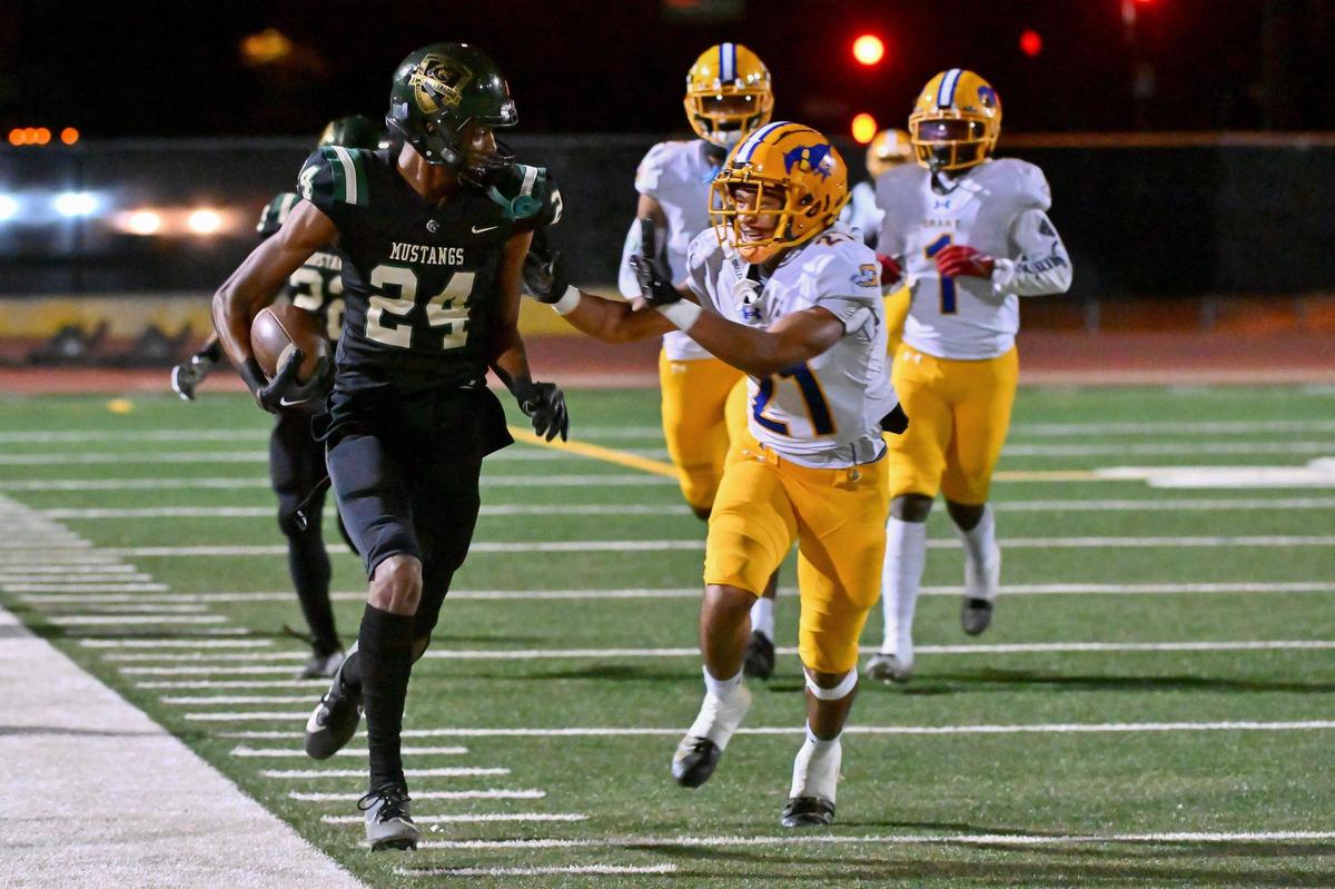 The Monterey Trail Mustangs’ Damian McAlister (24) runs the ball for 31 yards before being pushed out of bounds by the Grant Pacers’ Solomona J. Malae (21) on Friday.