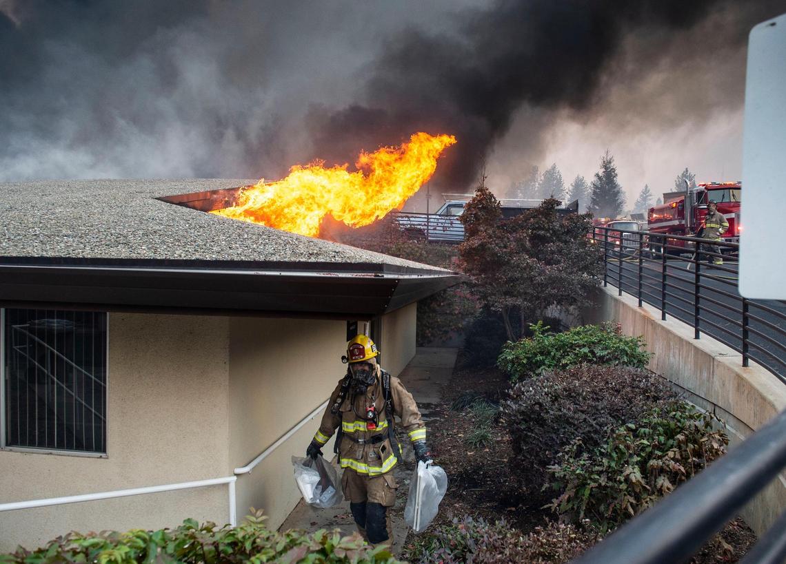 Josh Wilkins with Cal Fire removes belongings from the radiology building that was fully engulfed in flames at the Feather River hospital in Paradise as the Camp Fire raged on Thursday, Nov. 8, 2018.