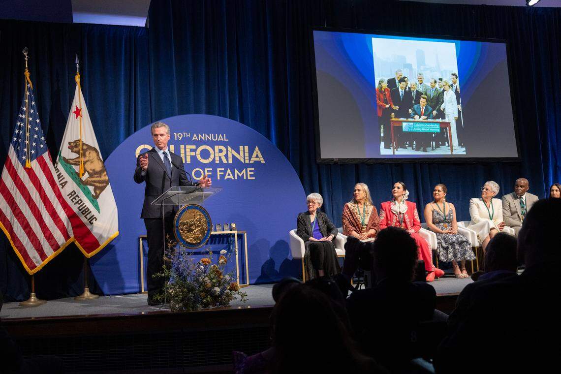 El gobernador Gavin Newsom presenta a Arnold Schwarzenegger, icono de Hollywood, campeón de culturismo y exgobernador de California, quien no estuvo presente, durante la inducción de la 19ª clase al California Hall of Fame en el California Museum el jueves 19 de marzo de 2026, en Sacramento.