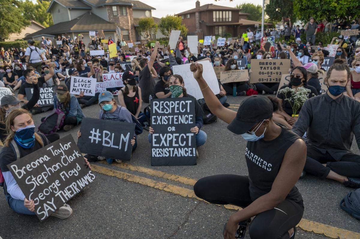 A protester raises her fist during the chant “hands up Stephon Clark,” during a Black Lives Matter Sacramento ‘die-in’ on Friday, June 5, 2020 in the Pocket neighborhood, where Sacramento Mayor Darrell Steinberg lives.