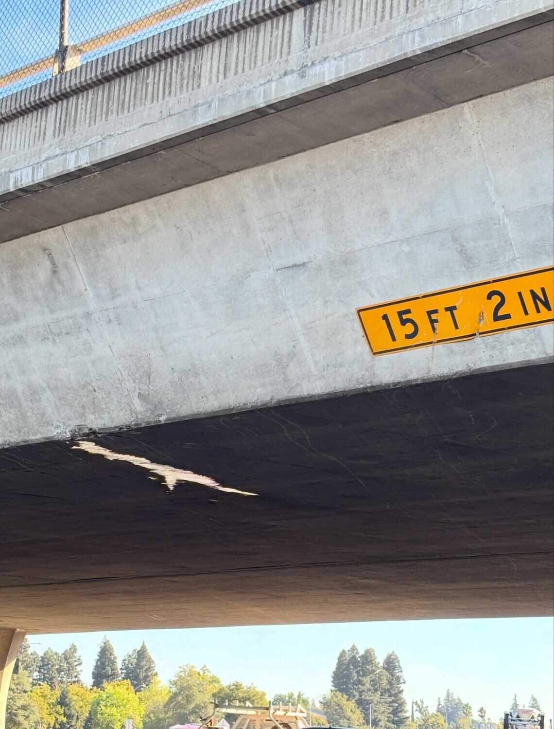 Damage is visible at the bottom of the Bradshaw Road crossing over the 50 Freeway in Rancho Cordova after a truck-towed backhoe struck the bridge Wednesday morning. The overpass has a clearance of 15 feet 2 inches.