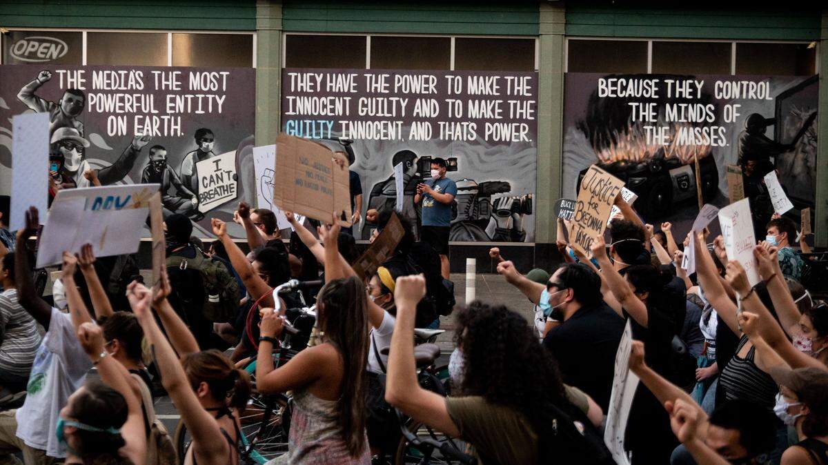 A peaceful march protesting police brutality and racism crosses in front a mural painted earlier in the day on the boarded up storefront of Rodney’s Cigar & Liquor at 10th and J streets in Sacramento on Thursday, June 4, 2020. Funeral services for George Floyd, who was killed by Minneapolis police on Memorial Day, were held earlier in Minnesota, the first of several tributes for Floyd in different cities in the coming days.