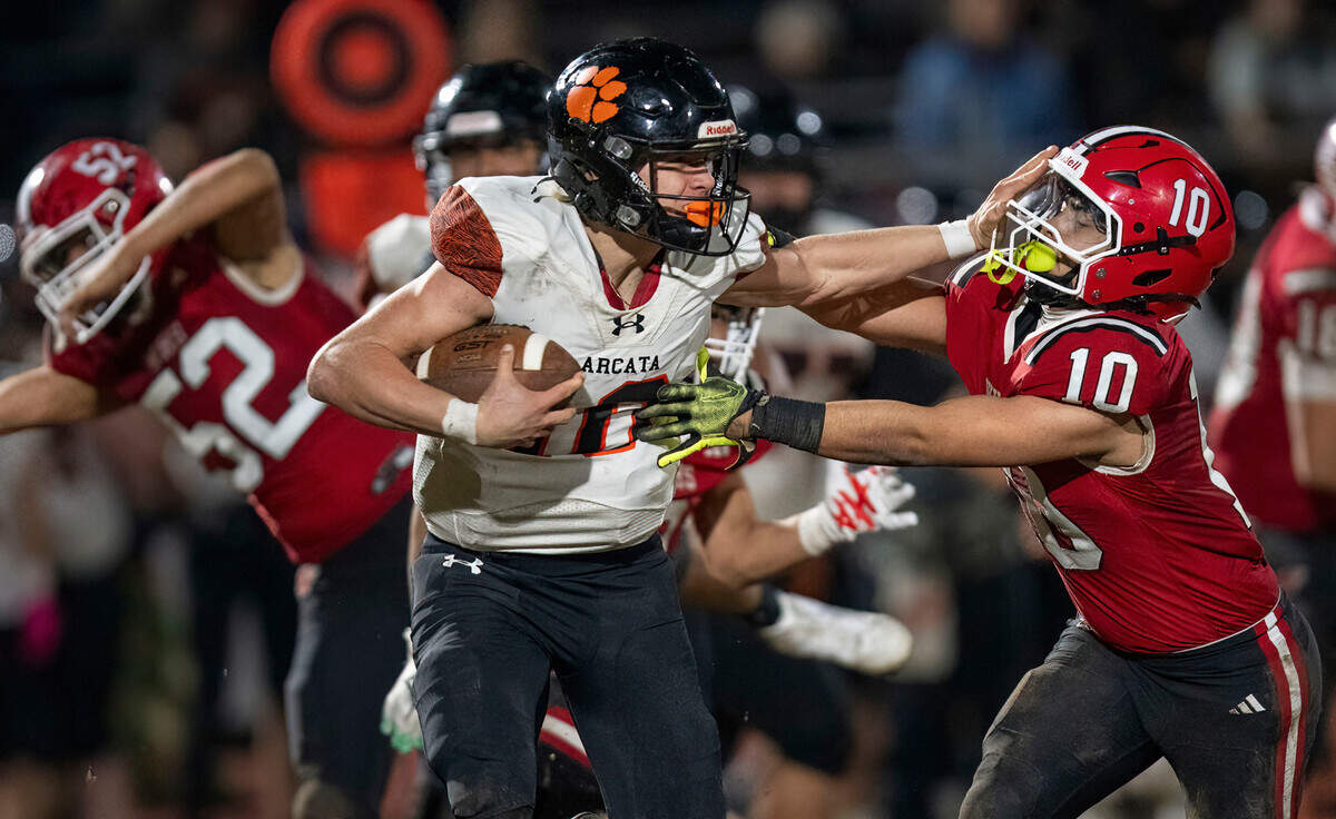 Arcata Tigers quarterback Luke Lemke (10) escapes the Winters Warriors’ Gio Jimenez (10) with a stiff arm to rush for a first down during the CIF Northern California Division 6-AA regional football championship game on Friday.