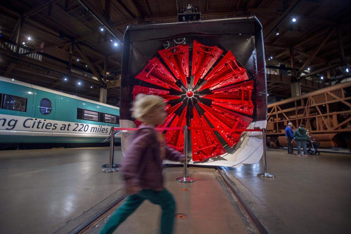 A child runs past a 251,000-pound rotary snowplow at an exhibit with information about the history of train snow removal at the California State Railroad Museum in Sacramento on Friday, Feb. 3, 2017.