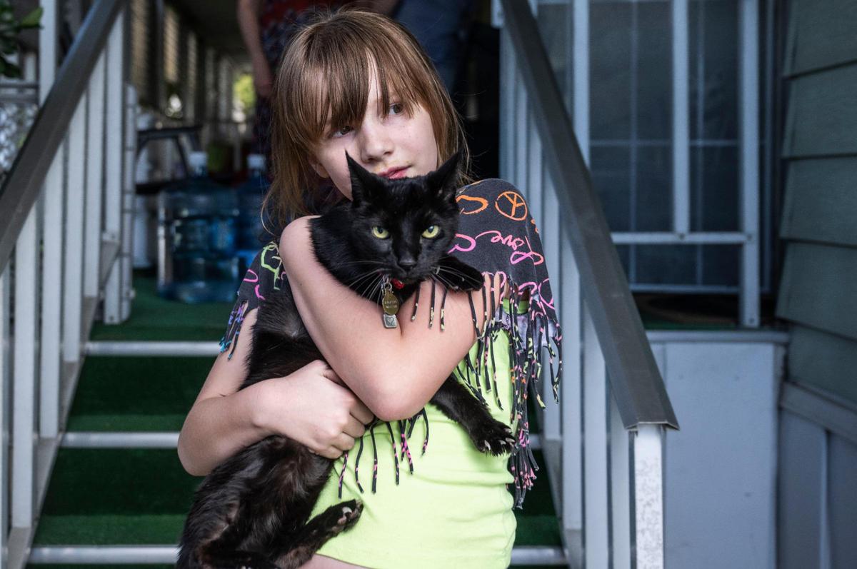 Mary Page, 10, a resident at Capital Mobile Estates holds her cat Reggie in front of their home last month. Page has grown up at the mobile home park and has made many friends there. Her mother said that new management has been harassing them with eviction threats.