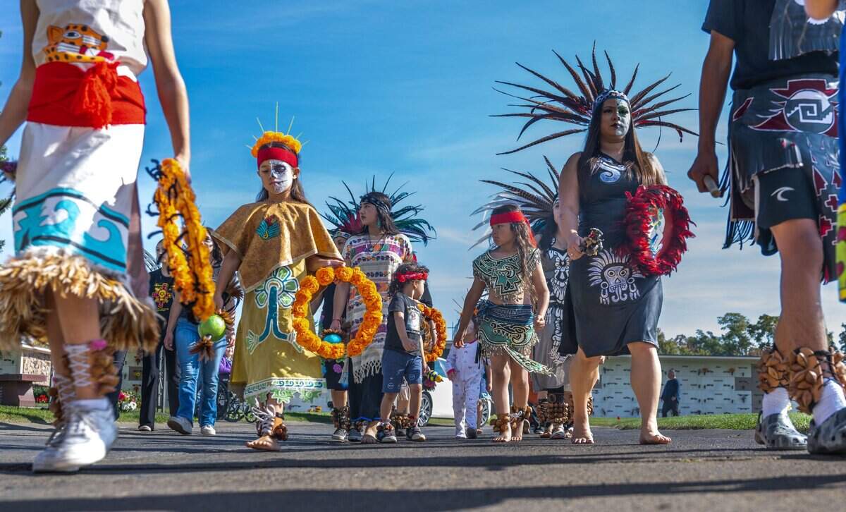 Aztec dancers walk in a procession during the 48th annual Dia de los Muertos observance on Nov. 2, 2023, at St. Mary’s Catholic Cemetery in Sacramento. Sacramento’s oldest event was started in 1975 by the Royal Chicano Air Force, a collective of artists and community activists.