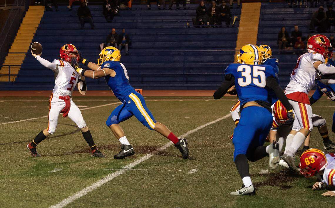 Grant Pacers defensive end Jeremiah Tuiileila (8) puts pressure on Oakdale Mustangs quarterback Tommy Chance in the CIF Sac-Joaquin Division III semifinal game in November.