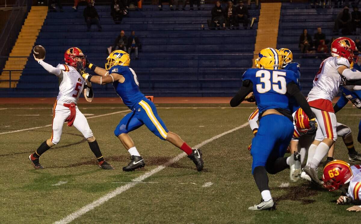 Grant Pacers defensive end Jeremiah Tuiileila (8) puts pressure on Oakdale Mustangs quarterback Tommy Chance (5) in a 2023 CIF Sac-Joaquin Division III semifinal game.