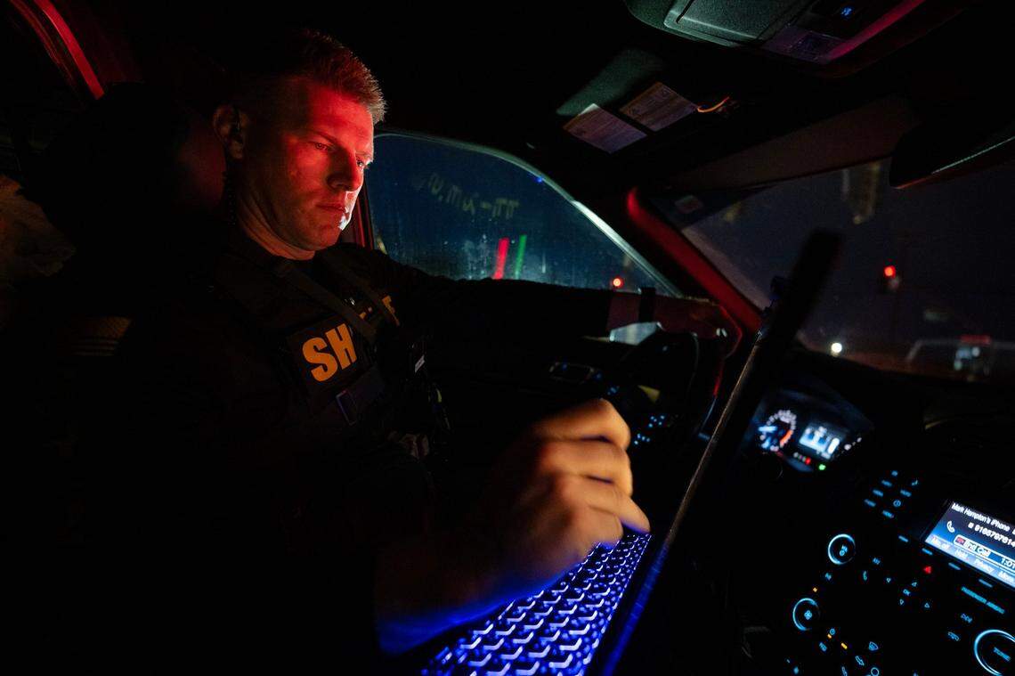 Sacramento Sheriff’s deputy Eilers searches for prior convictions after arresting a man who propositioned a female deputy posing as prostitute on Watt Avenue in North Highlands on Friday.