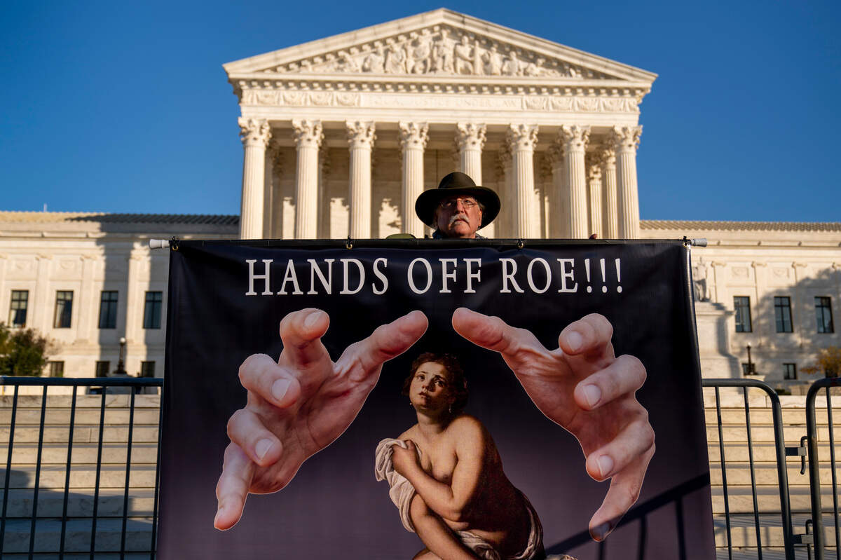 Stephen Parlato of Boulder, Colo., holds a sign outside the U.S. Supreme Court in late November.