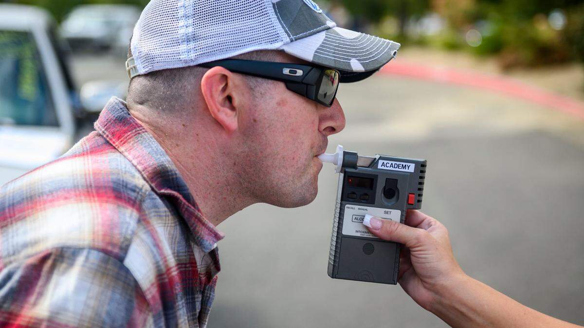 CHP officer Mike Maher blows into a breathalyzer during a 2019 DUI investigation simulation.