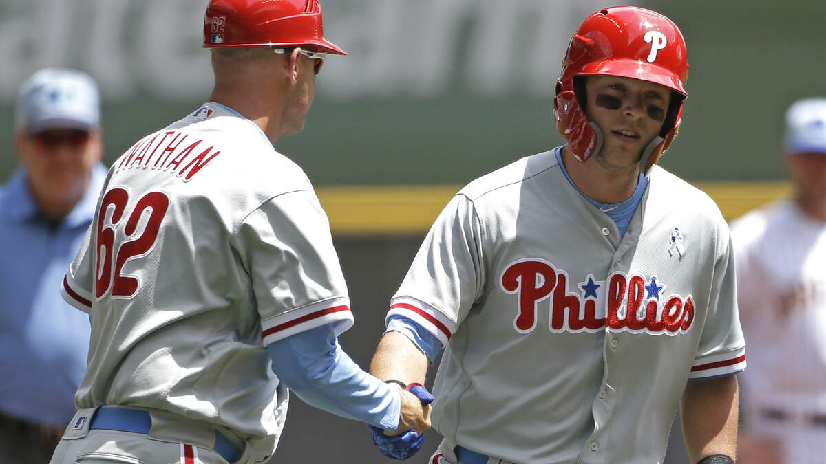 The Philadelphia Phillies’ Rhys Hoskins, right, is congratulated by Dusty Wathan after hitting a home run against the Milwaukee Brewers June 17 in Milwaukee.