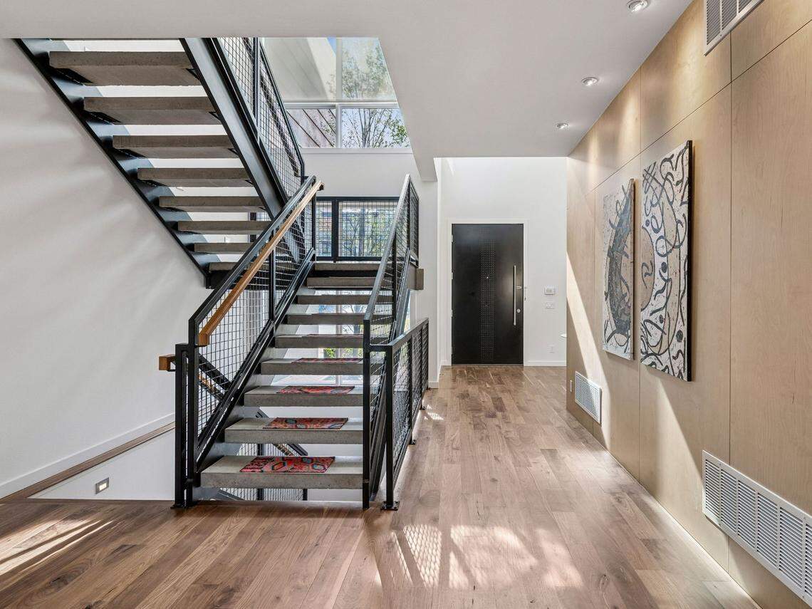 The open floor plan is flooded with natural light from expansive east and west-facing windows.