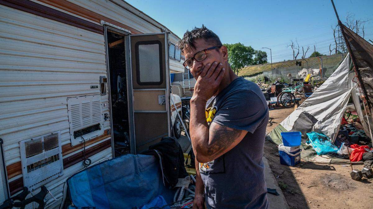 Erick Read, 48, stands near a camper he’s living in along Lathrop Way iin Sacramento on Wednesday, April 21, 2021, and talks how he became homeless when he lost his restaurant job during the pandemic. “We were in South Natomas and cops evicted us from that spot and told us to come here,” said Read. “I’d like to get a job and pay rent somewhere. That’s all I want in life.”