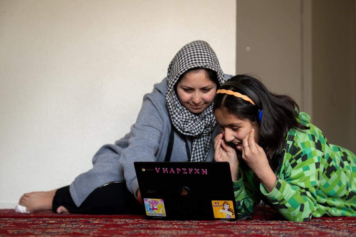 Marzia Ahmadi watches last month as her hearing-impaired daughter, Zohra, 12, learns school lessons with a laptop in their Yuba City apartment.