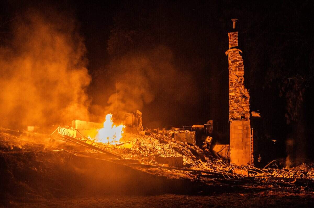 A fire burns at the remnants of a house during the River Fire on Mount Olive Road in Chicago Park on Thursday, Aug. 5, 2021.