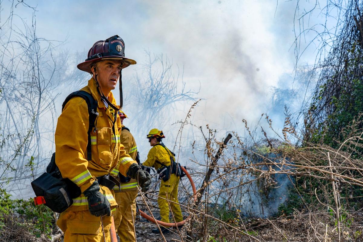 Firefighters work to put out a two-alarm fire near Discovery Park on the American River Parkway in March. The slow-spreading fire was in a difficult area to access.