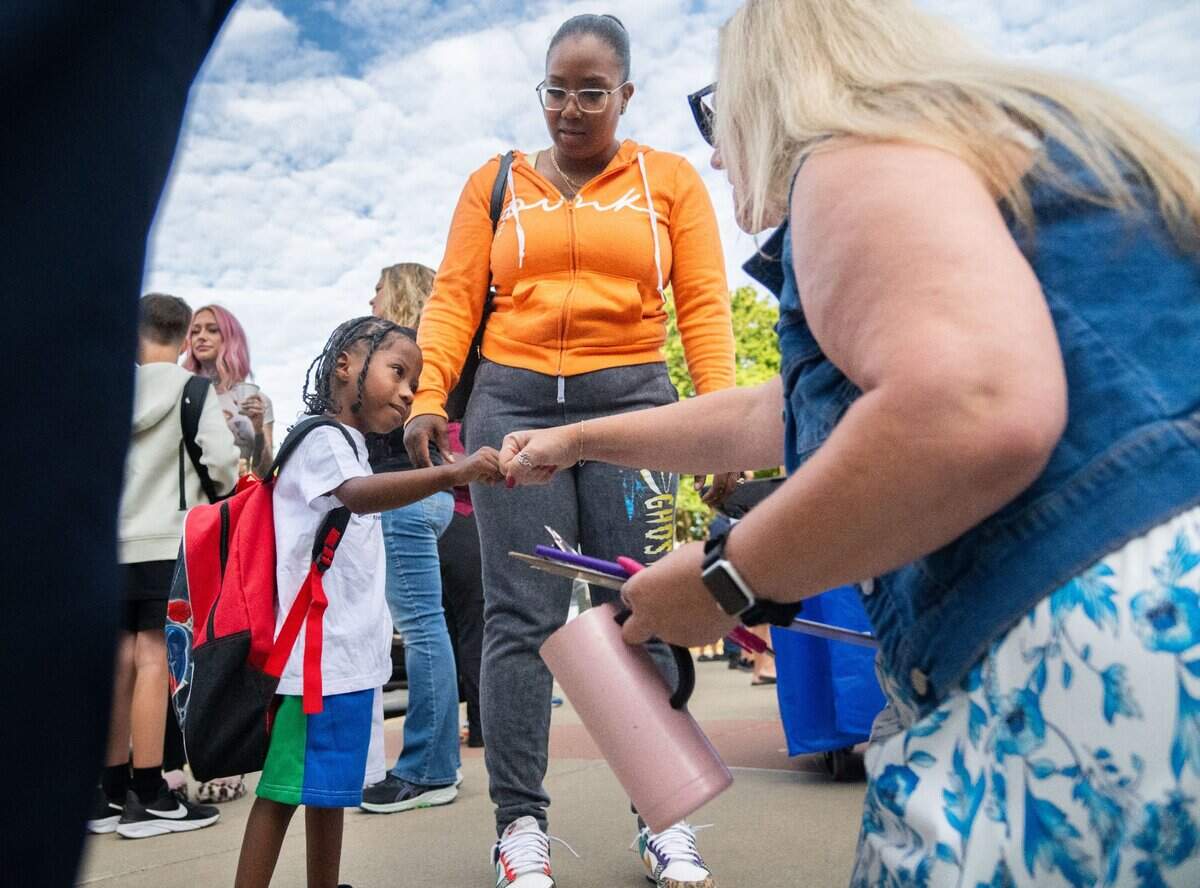 Transitional kindergartner Zyaire King Jacob Gooden, left, fist bumps teacher Jamie Emerick while his mother, Bianca Rodrigues, center, watches on the first day of classes at Williamson Elementary School in Rancho Cordova on Thursday. “He’s like a little busy bee, so I’m happy that he’s able to wake up early in the morning and go to school with his brother because it makes him feel like a big boy,” Rodrigues said.