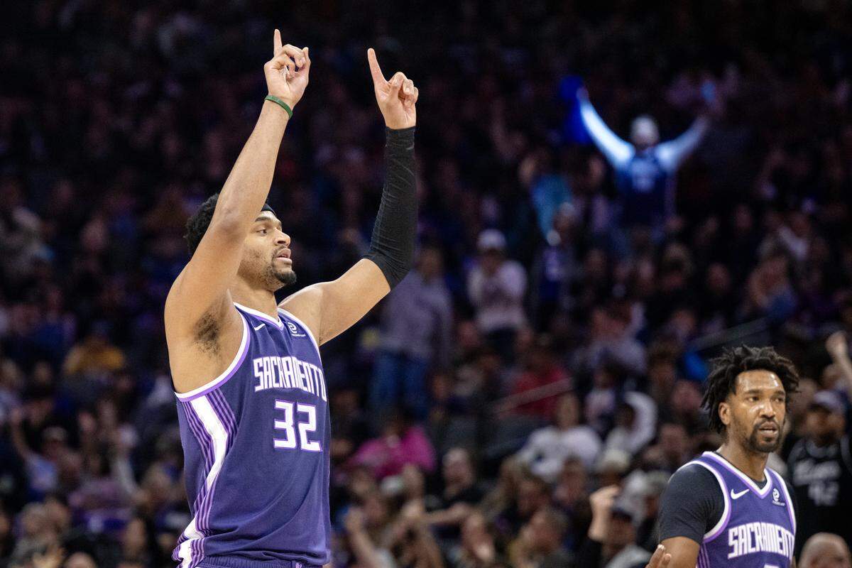 Sacramento Kings center Dylan Cardwell (32) raises his arms after making a three point shot at the end of the first quarter against the Golden State Warriors on Friday at Golden 1 Center.