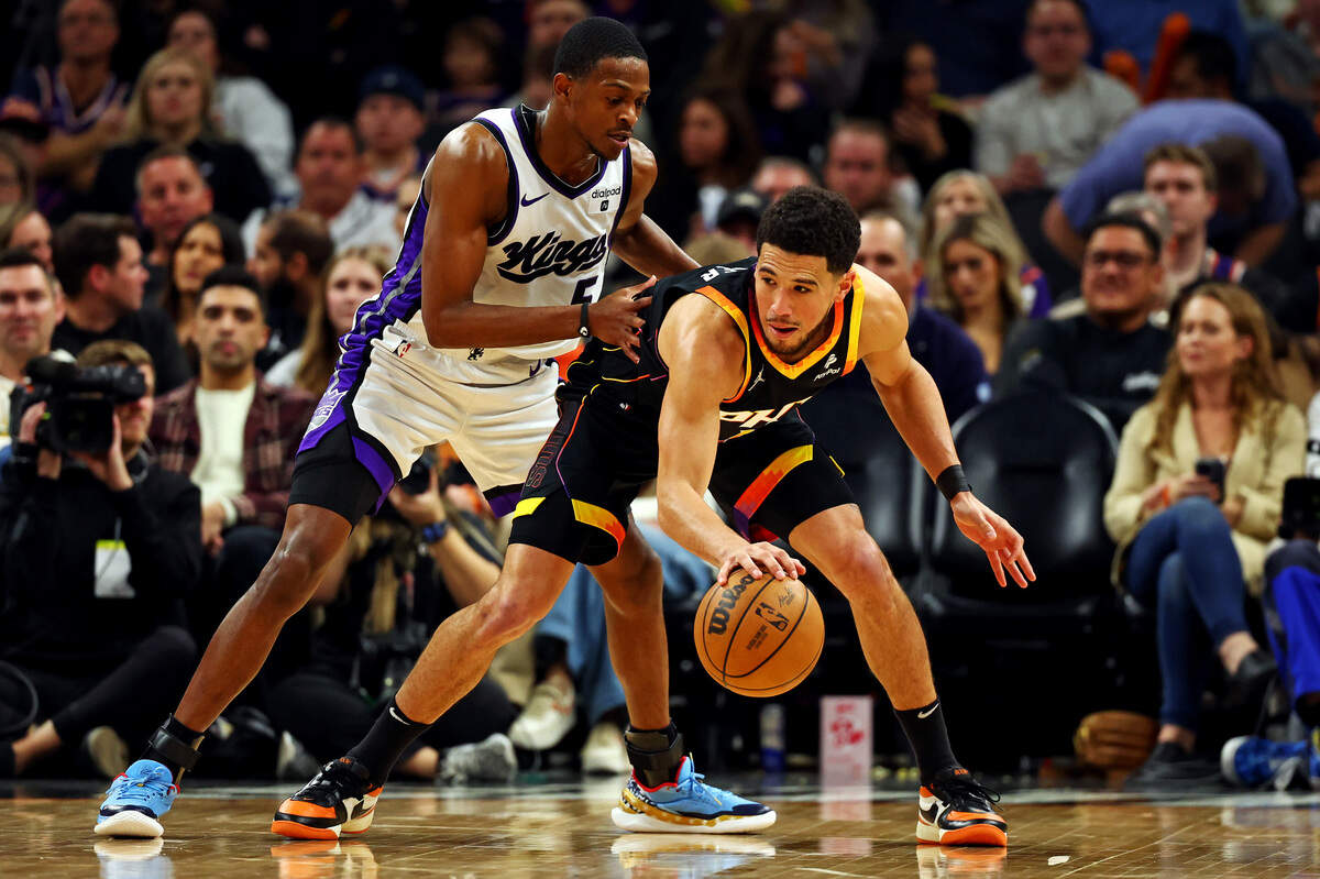 Phoenix Suns guard Devin Booker (1) handles the ball against Sacramento Kings guard De’Aaron Fox (5) during the third quarter Jan. 16, 2024, at Footprint Center in Phoenix, Arizona.