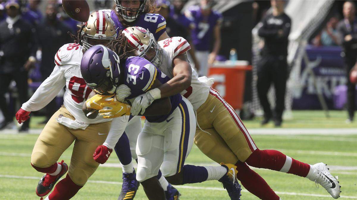 Minnesota Vikings running back Dalvin Cook (33) fumbles the ball as he is tackled by 49ers linebacker Fred Warner, right, Sunday in Minneapolis.