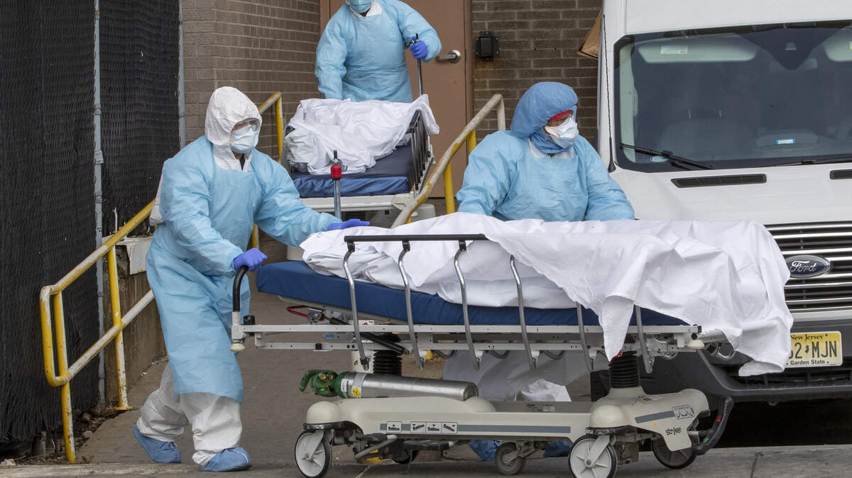 Medical personnel wearing personal protective equipment remove bodies from the Wyckoff Heights Medical Center, Thursday, April 2, 2020 in the Brooklyn borough of New York. As coronavirus hot spots and death tolls flared around the U.S., the nation’s biggest city was the hardest hit of the all, with bodies loaded onto refrigerated morgue trucks by gurney and forklift outside overwhelmed hospitals, in full view of passing motorists. . (AP Photo/Mary Altaffer)