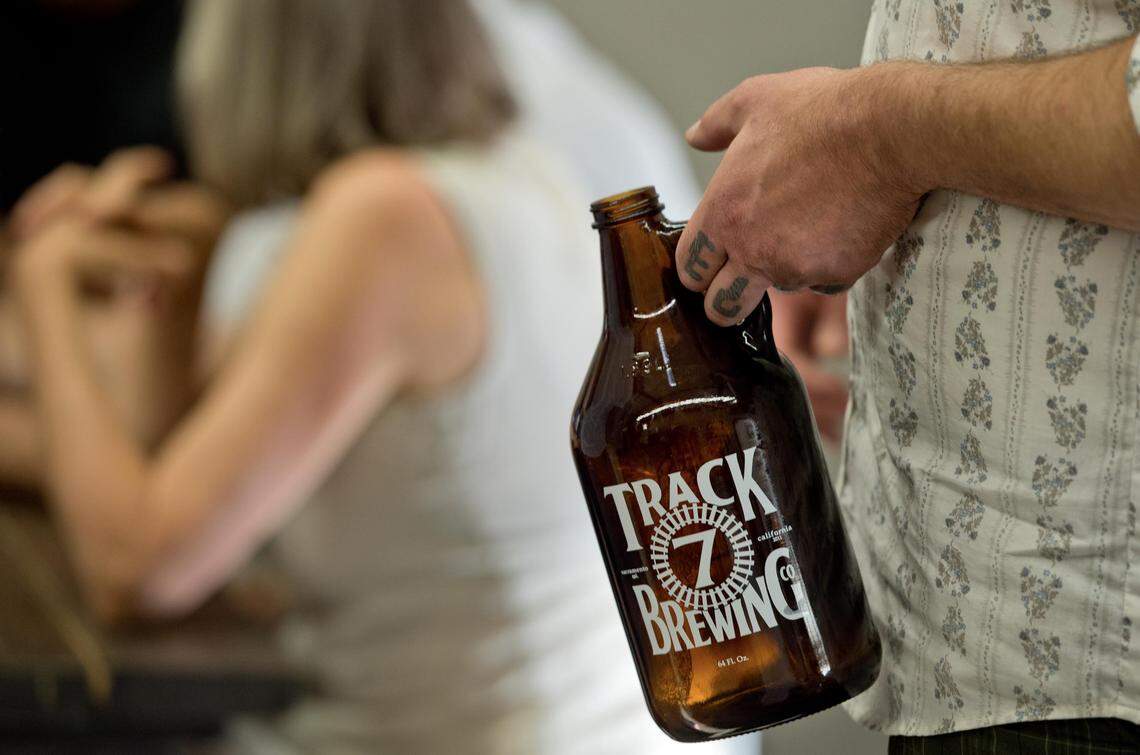 A man carries an empty growler into the Curtis Park Track 7 tasting room in 2013. The brewery closed its locations in May after 13 years in business.