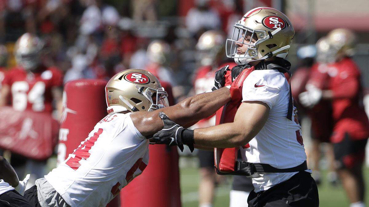 Defensive players Solomon Thomas, left, and Nick Bosa perform drills during the first day of 49ers training camp Saturday in Santa Clara.