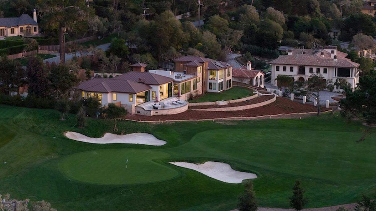 Walls of glass open the living room to sweeping Pacific views and the 14th fairway at the 17 Mile Drive estate.