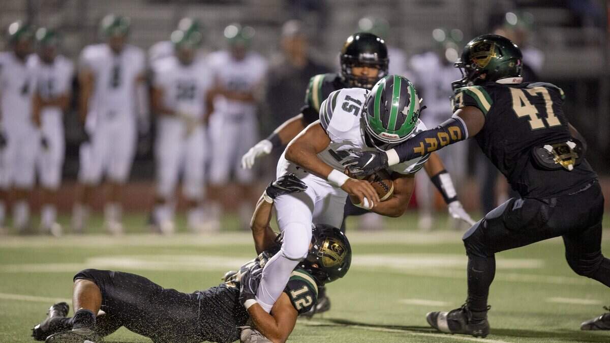 Pitman’s Payton Bass (15) is stopped by Monterey Trail’s Brandon Hwa (12) and Germaine Spearman (47) for a 2-yard loss in the first quarter of their Sac-Joaquin playoff game Friday, November 9, 2018 in Elk Grove.