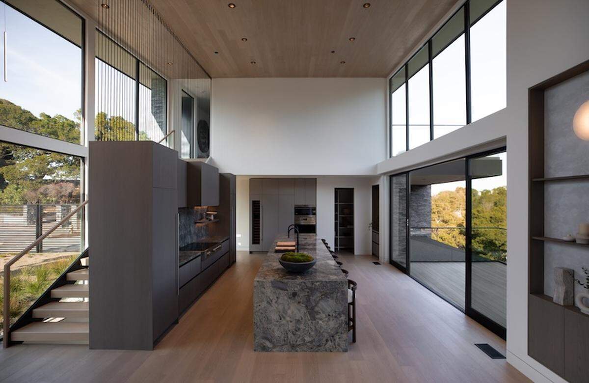 A showstopping custom bar lounge with floating stone shelves exemplifies the home’s refined elegance.