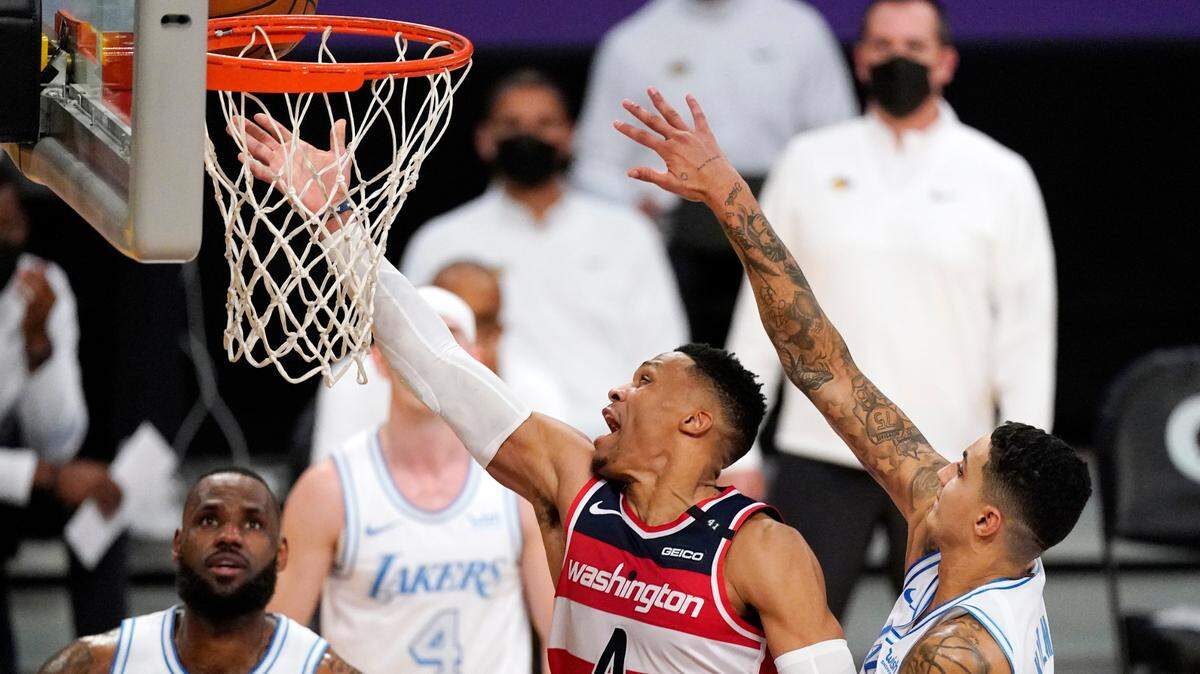 Washington Wizards guard Russell Westbrook, second from right, shoots as Los Angeles Lakers forward Kyle Kuzma, right, defends along with forward LeBron James during overtime in an NBA basketball game Monday, Feb. 22, 2021, in Los Angeles. The Wizards won 127-124 in overtime. (AP Photo/Mark J. Terrill)