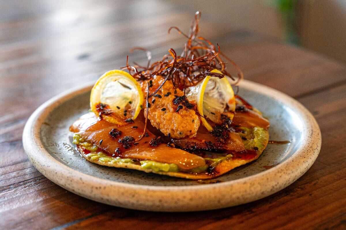 The salmon sashimi tostada is on the secret menu at StreetZlan in Elk Grove on July 24. The dish is topped with guacamole, cured salmon slices, pureed salmon, lemon slices, togarashi and drizzled with salsa macha.
