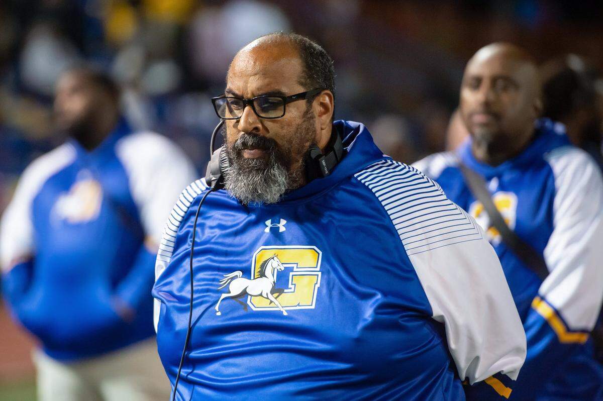 Grant head coach Carl Reed stands for the national anthem before the game against the Monterey Trail Mustangs in October.
