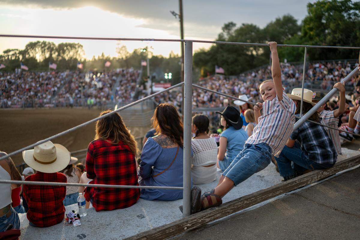 Regan Nichols hangs onto the railing in the stands during the Folsom Pro Rodeo in Folsom on Thursday.