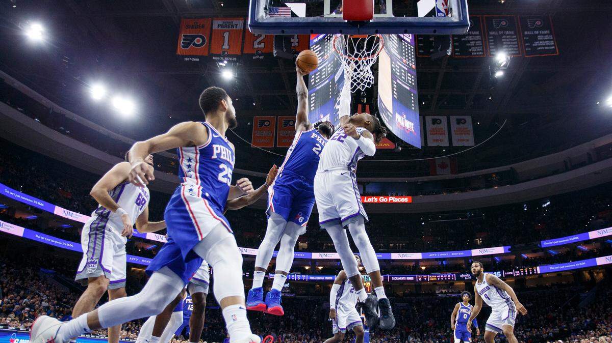 Philadelphia 76ers’ Joel Embiid, center, goes up for the dunk over Sacramento Kings’ Richaun Holmes, right, during the first half of an NBA basketball game, Wednesday, Nov. 27, 2019, in Philadelphia. (AP Photo/Chris Szagola)