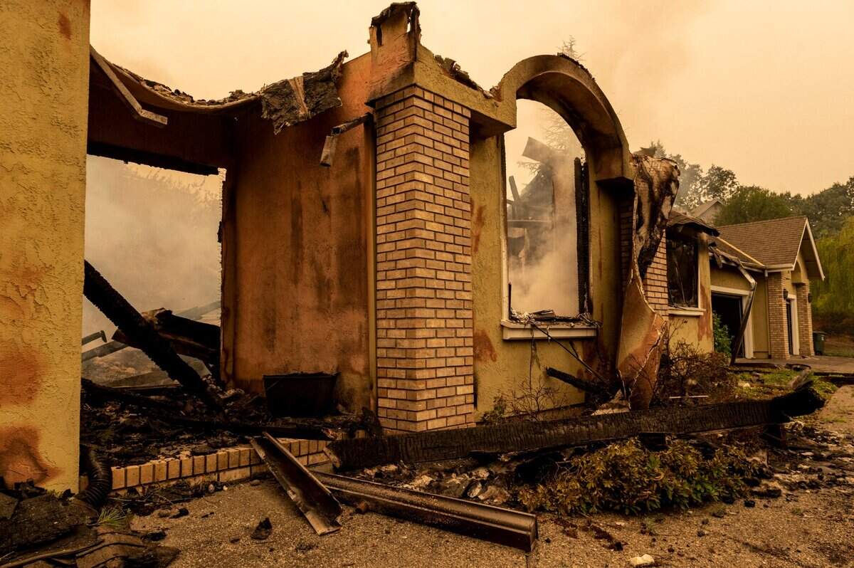 A house smolders on Meadowstone Drive in Oakmont Village in Santa Rosa on Monday after being burned by the Glass Fire.