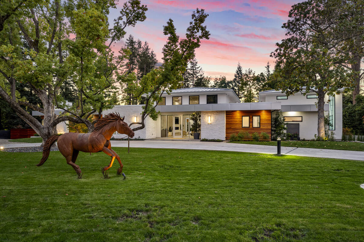 A bronze horse statue and a mature oak anchor the gated front approach at 3630 Winding Creek Road, a property with a roughly 5,000-square-foot main home listed at $4.5 million in Arden Oaks.
