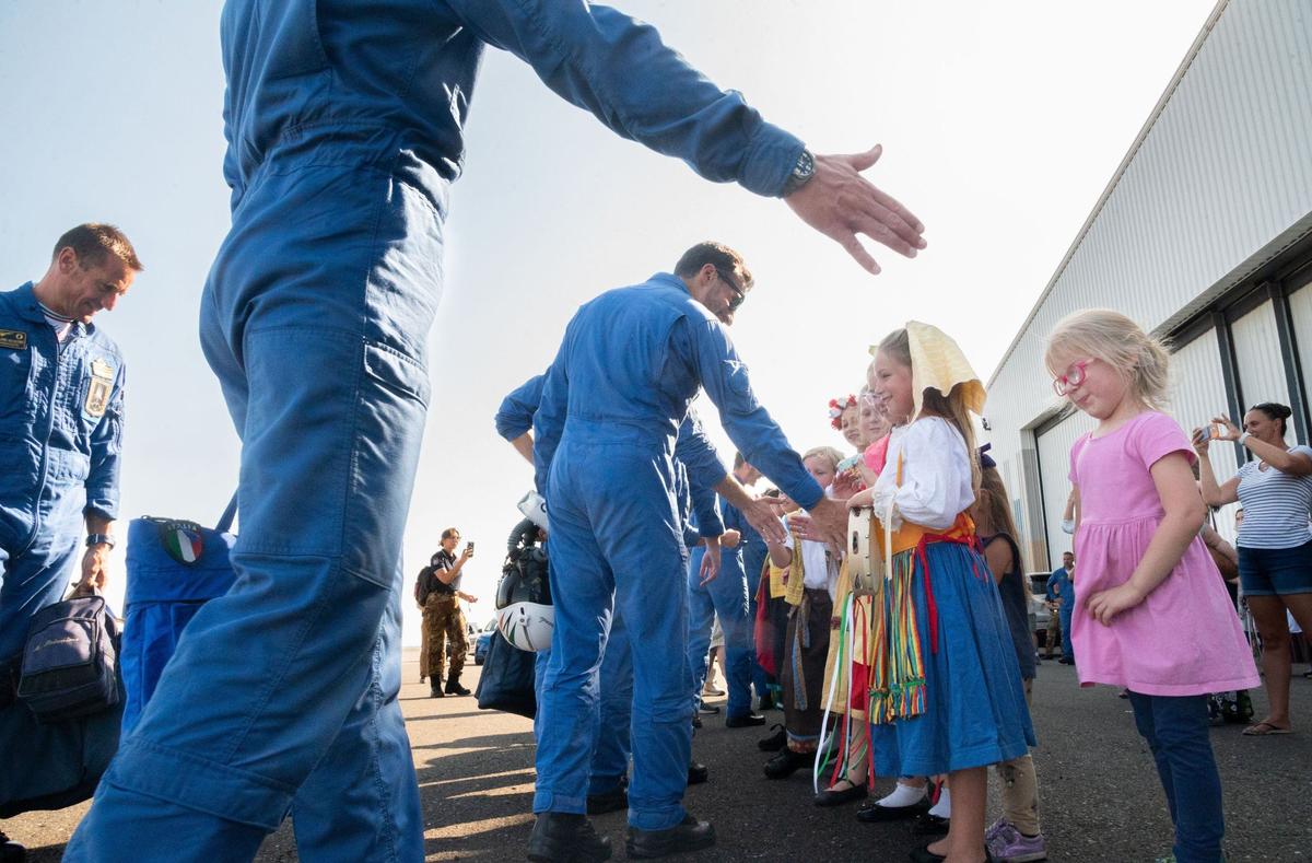 Pilots with Frecce Tricolori, the Italian Air Force aerobatic team, high-five a line of onlookers – some dressed in traditional Italian clothing – after arriving at Mather Airport near Rancho Cordova on Tuesday, July 9, 2024. This tour is the first time in more than 30 years that the Italian Air Force has deployed its aircraft and personnel to North America.